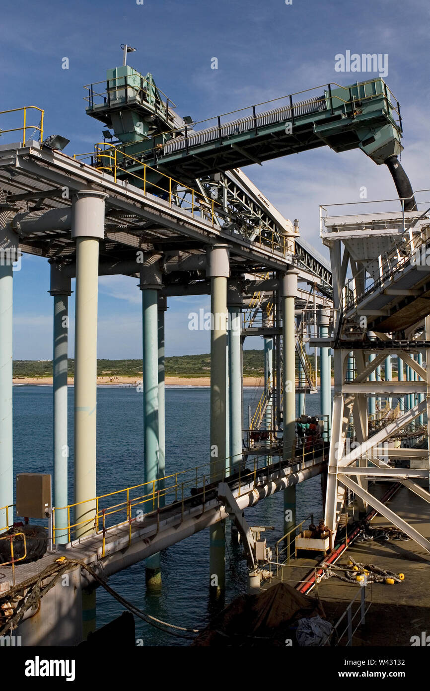Mining, managing & transporting of titanium mineral sands. From floating jetty up to main one loading product into barge via boom & 'elephant trunk'. Stock Photo