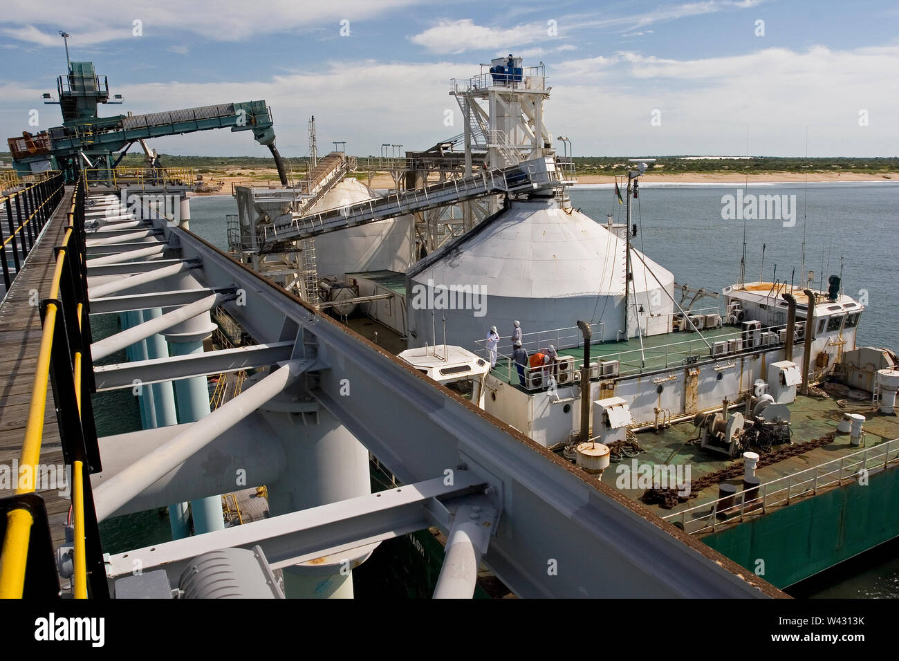 Mining, managing & transporting of titanium mineral sands. Port facility with loading barge hoppers with product via boom before transhipment.to OGV. Stock Photo