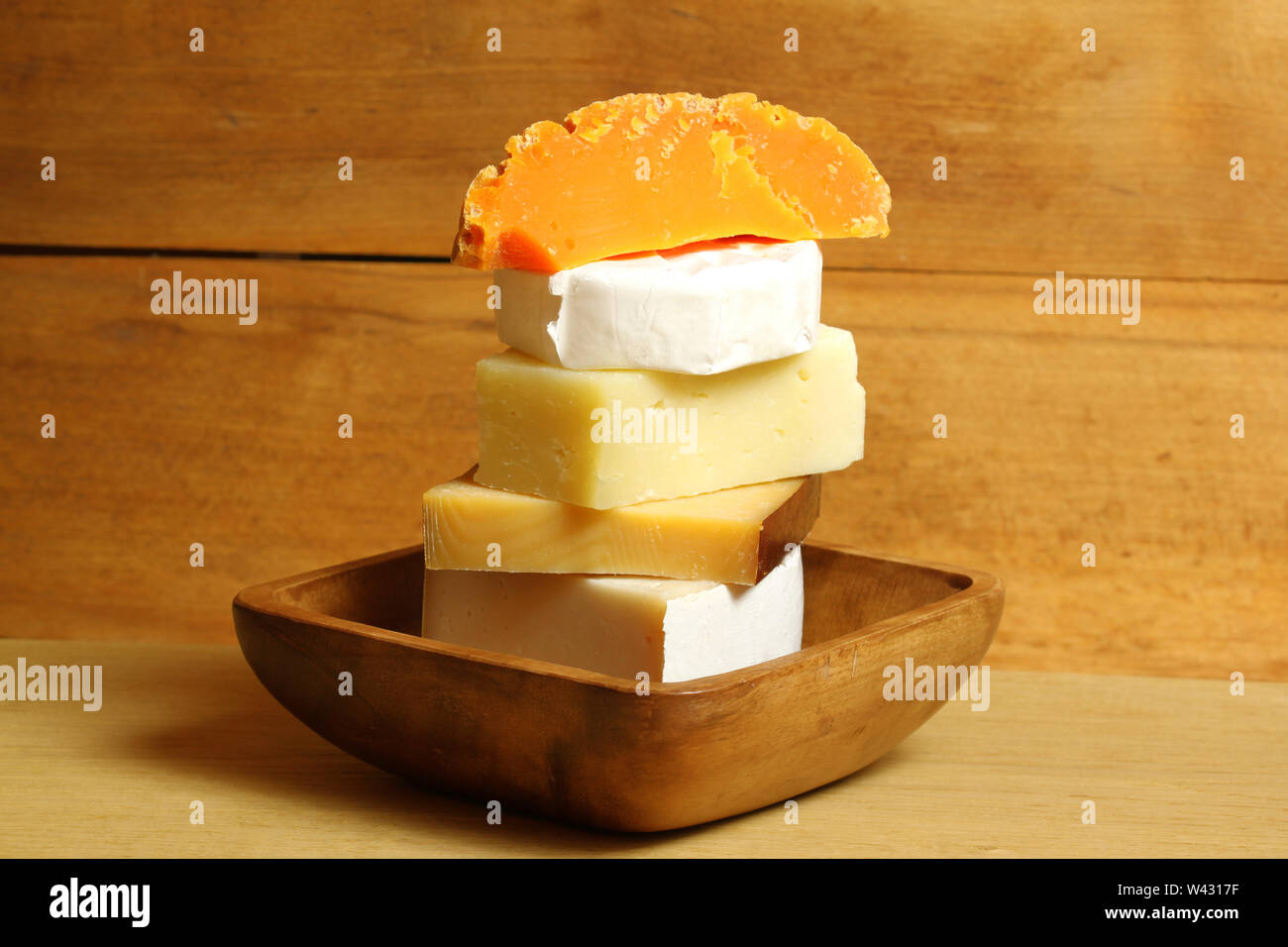 Stack of hard and soft cheese kinds in rustical scenery Stock Photo