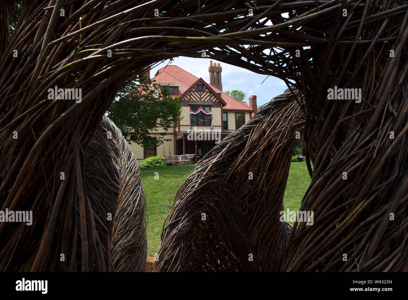 Highfield Hall, Falmouth, Massachusetts on Cape Cod. A Historic (1878) summer mansion. Photographed through 'Stickwork' by artist Patrick Dougherty. Stock Photo