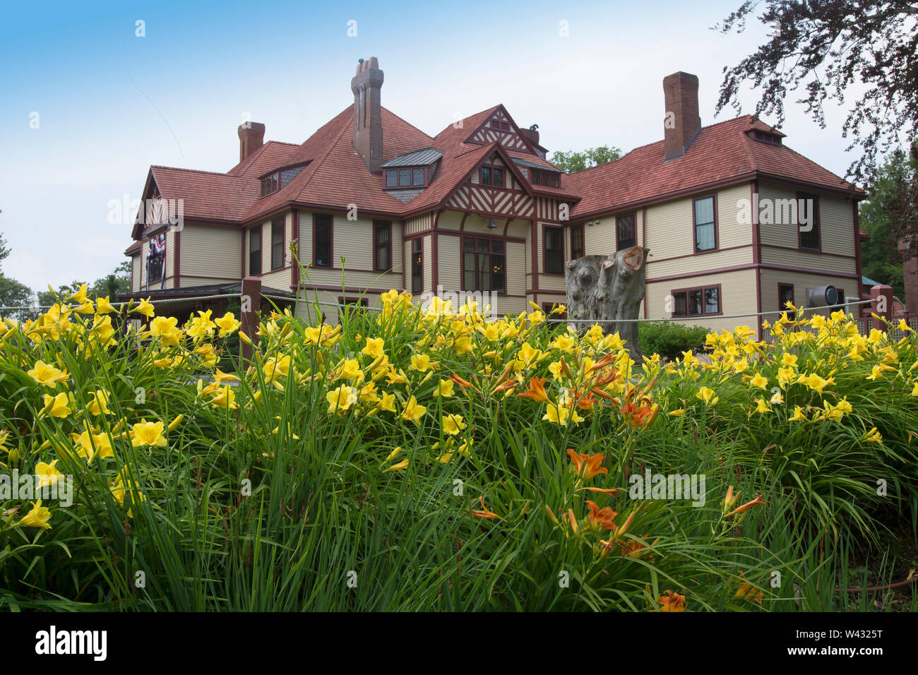Highfield Hall, Falmouth, Massachusetts on Cape Cod. A Historic (1878) summer mansion as seen though a garden of Day Lillies. Stock Photo