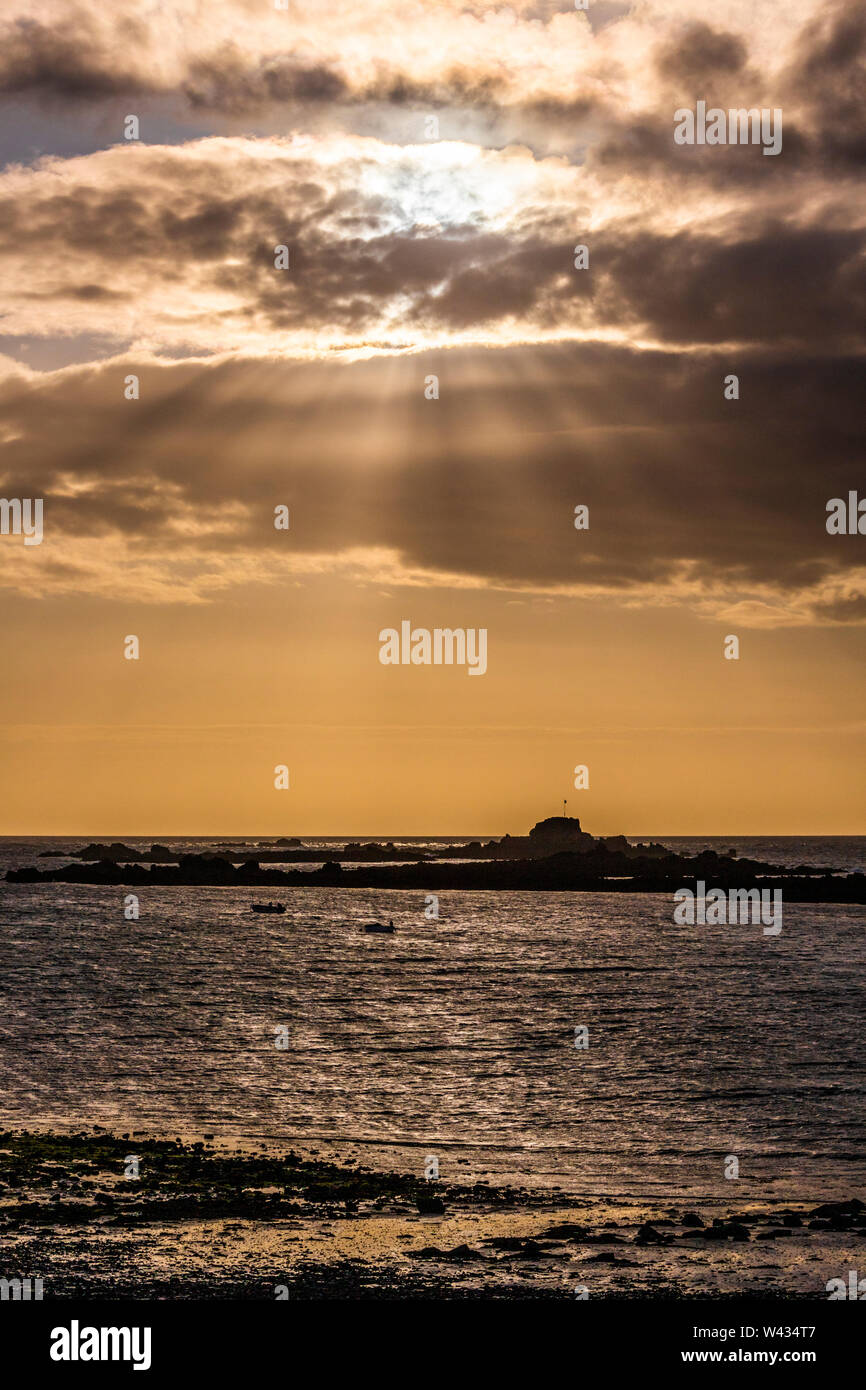 The sun setting over Cobo Bay, Guernsey, Channel Islands UK Stock Photo