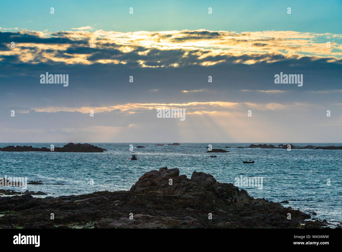 The sun setting over Cobo Bay, Guernsey, Channel Islands UK Stock Photo