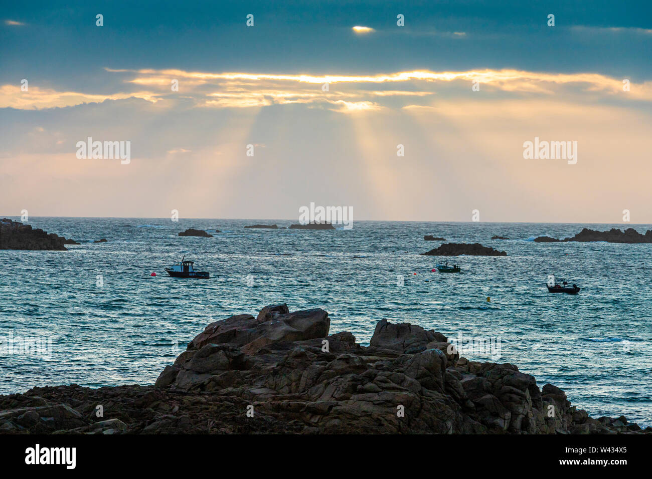 The sun setting over Cobo Bay, Guernsey, Channel Islands UK Stock Photo