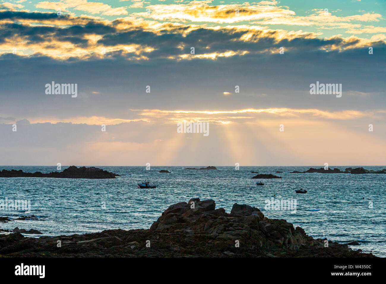 The sun setting over Cobo Bay, Guernsey, Channel Islands UK Stock Photo