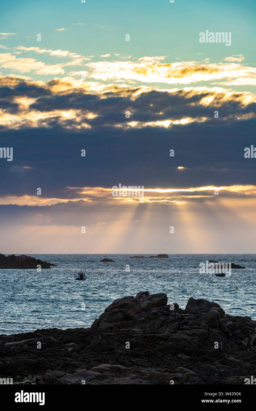 The sun setting over Cobo Bay, Guernsey, Channel Islands UK Stock Photo