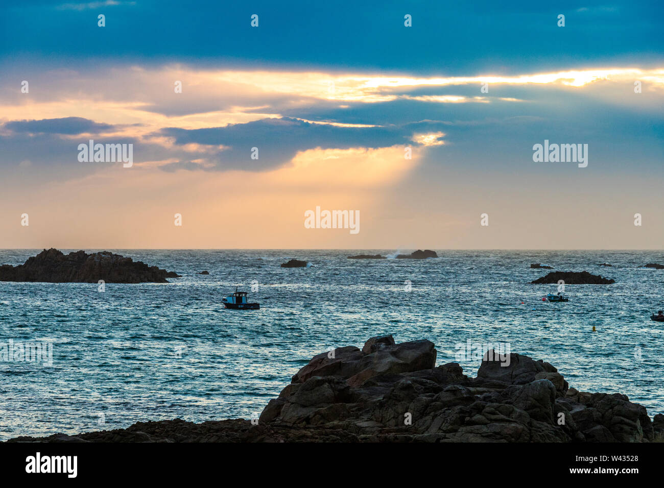 The sun setting over Cobo Bay, Guernsey, Channel Islands UK Stock Photo