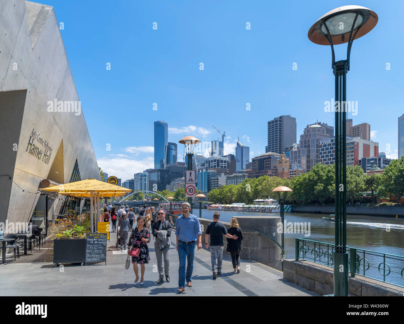 Southbank promenade along the Yarra River with Harmer Hall to left and skyline of the Central Business District behind, Melbourne, Victoria, Australia Stock Photo