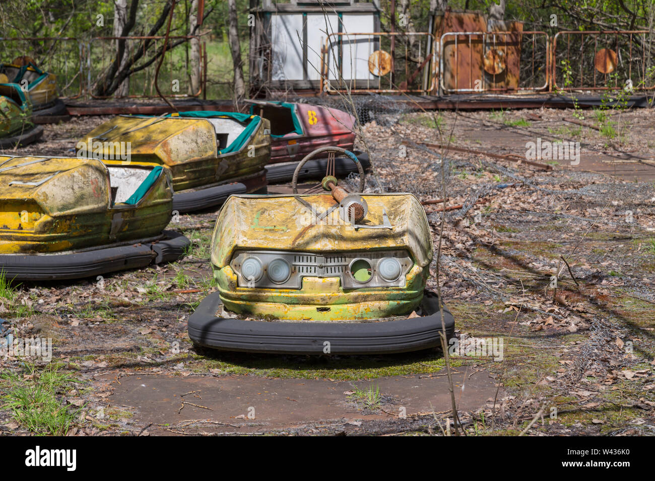 Old broken rusty metal radioactive children's electric cars  abandoned, the park of culture and recreation in the city of Pripyat, the Chernobyl disas Stock Photo