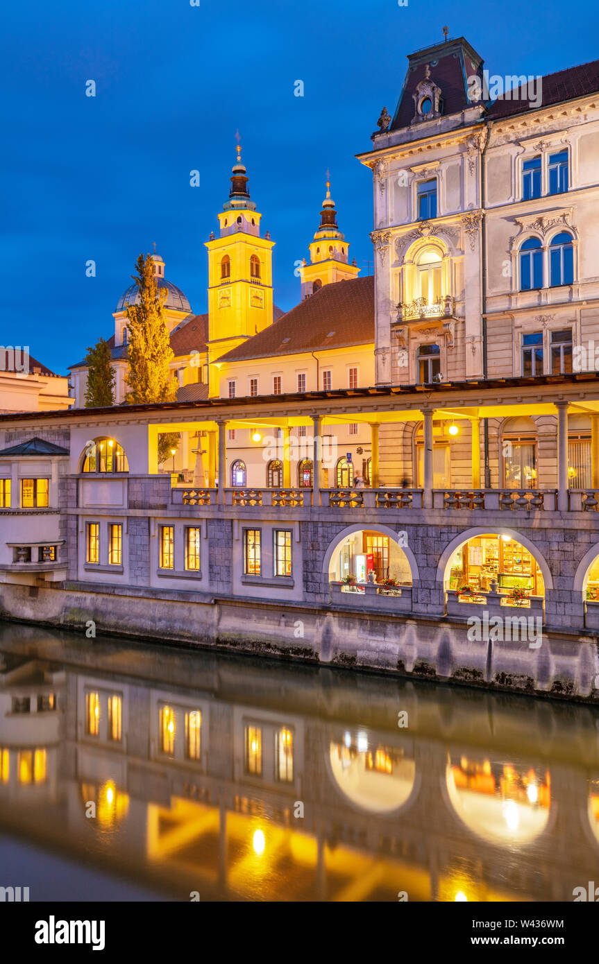 Night reflections of the arches of Plečnik's Arcades of the central covered Market place columns in the Ljubljanica river Ljubljana Slovenia EU Europe Stock Photo