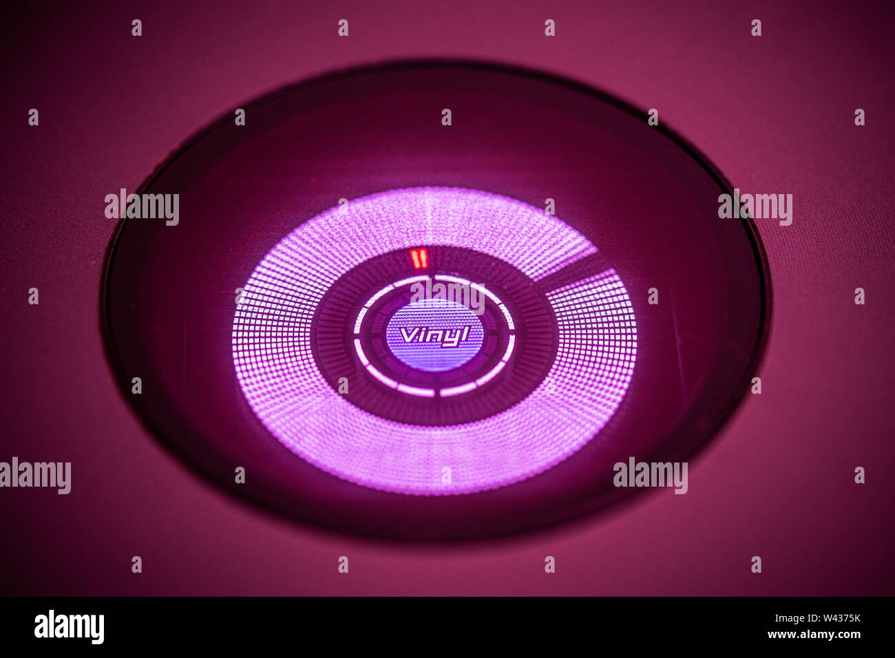 JULY 19, 2019 - MALAGA, SPAIN. Closeup of spinning 'Vinyl' play indicator on a Pioneer CDJ 800 Mk2 CD player. Magenta stage lighting Stock Photo