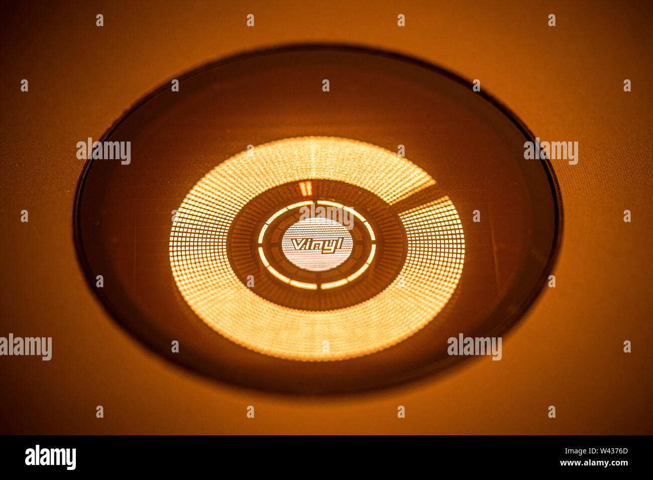JULY 19, 2019 - MALAGA, SPAIN. Closeup of spinning 'Vinyl' play indicator on a Pioneer CDJ 800 Mk2 CD player. Orange stage lighting Stock Photo