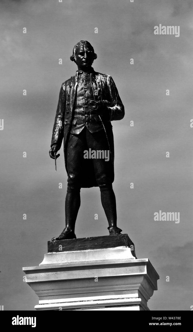 A staute of Captain James Cook stands looking over the harbour at Whitby where the young Cook learnt his trade as a navigator and later ships Captain Stock Photo