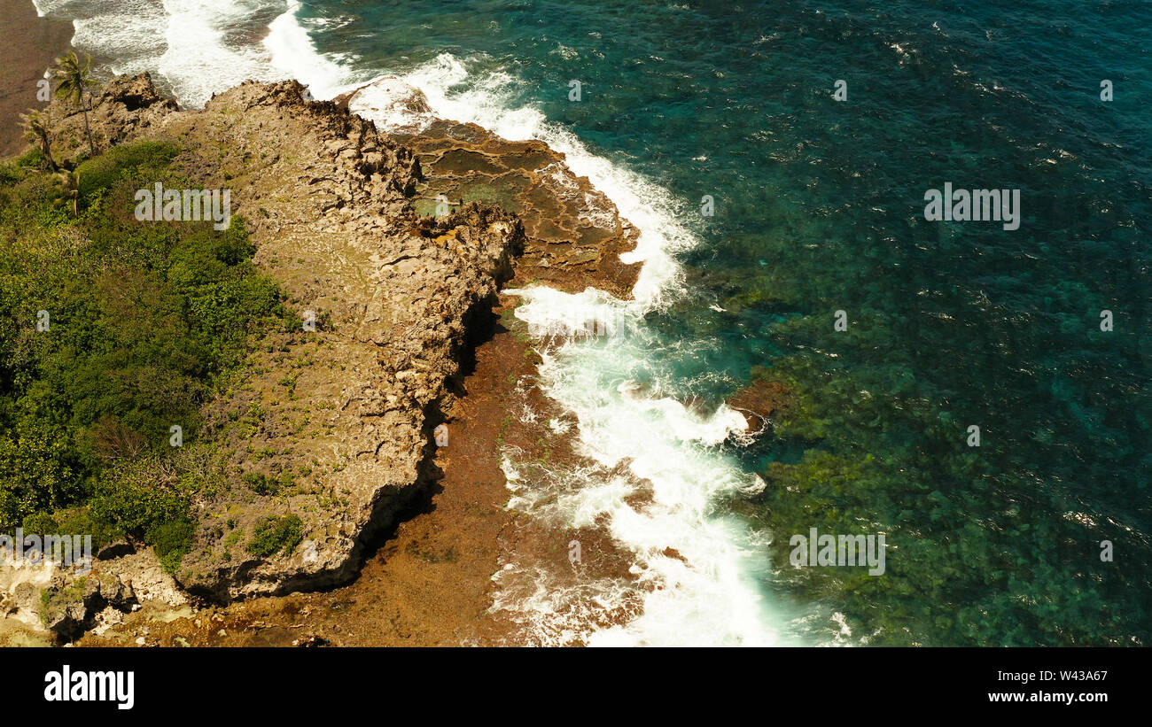 Ocean waves crashing on rocky shore from above. Siargao, Philippines. Summer and travel vacation concept Stock Photo
