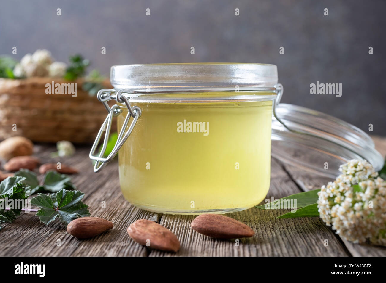 A jar of almond oil in which yarrow, common mallow and ribwort plantain