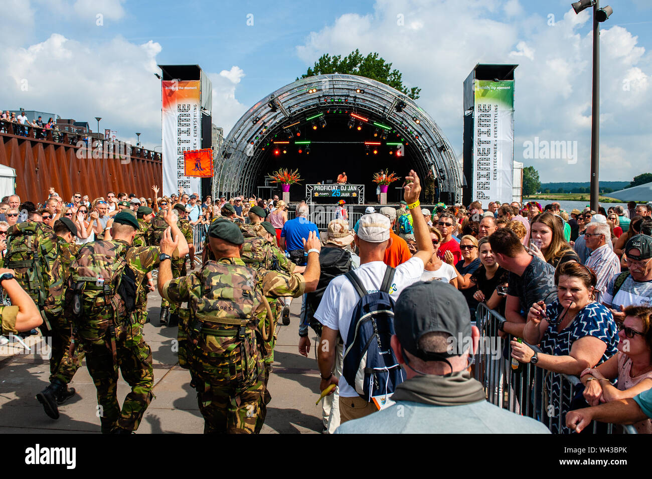 Soldiers dance while walking during the event.Since it is the world’s biggest multi-day walking event, the Four Days March is seen as the prime example of sportsmanship and international bonding between military servicemen and women and civilians from many different countries. This year marks the 75th anniversary of the pontoon bridge that has been set up each year temporarily over the River Meuse at Cuijk. The final kilometers are at the Via Gladiola Street, where as tradition every participant carries gladiolus plants and are welcomed by relatives and partners. Stock Photo