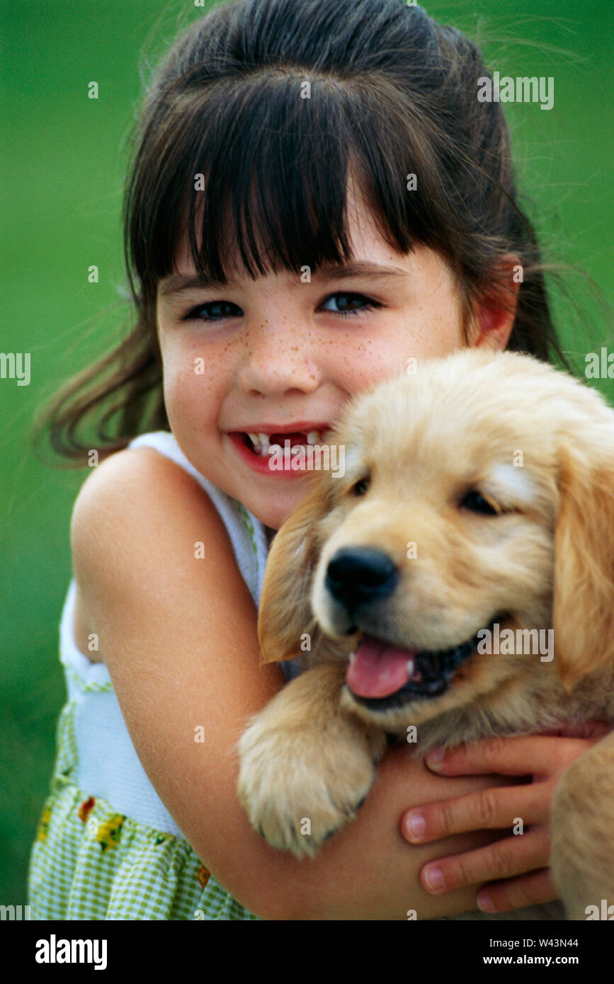 Young girl holding a golden retriever puppy Stock Photo Alamy