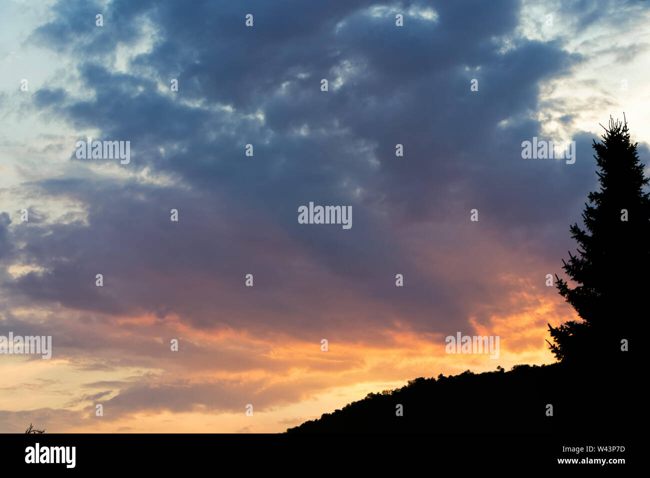 Beautiful colorful sunset clouds with the silhouette of a mountain and ...