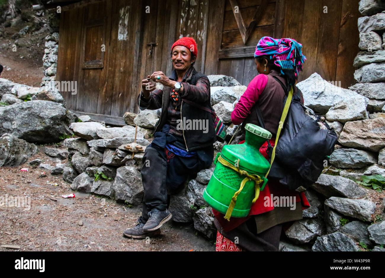 People of the Manaslu region preparing Yak wool for making clothes and handicrafts along the way to home. Stock Photo