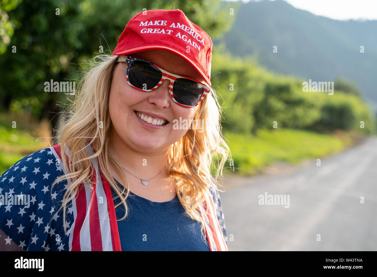 Wenatchee, Washington - July 4, 2019: Cute Republican woman wearing a MAGA hat (Make America Great Again) supporting President Donald Trump and his 20 Stock Photo