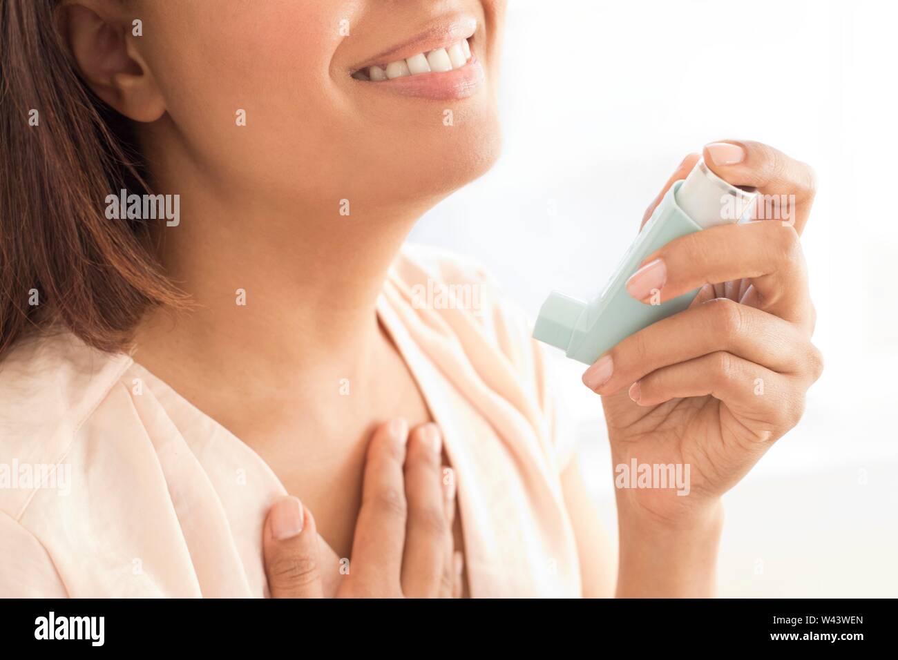 Woman using inhaler. Stock Photo