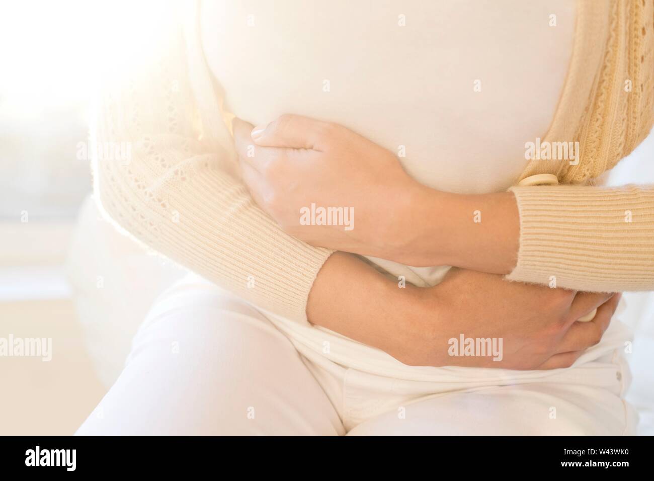 Woman holding stomach in pain. Stock Photo