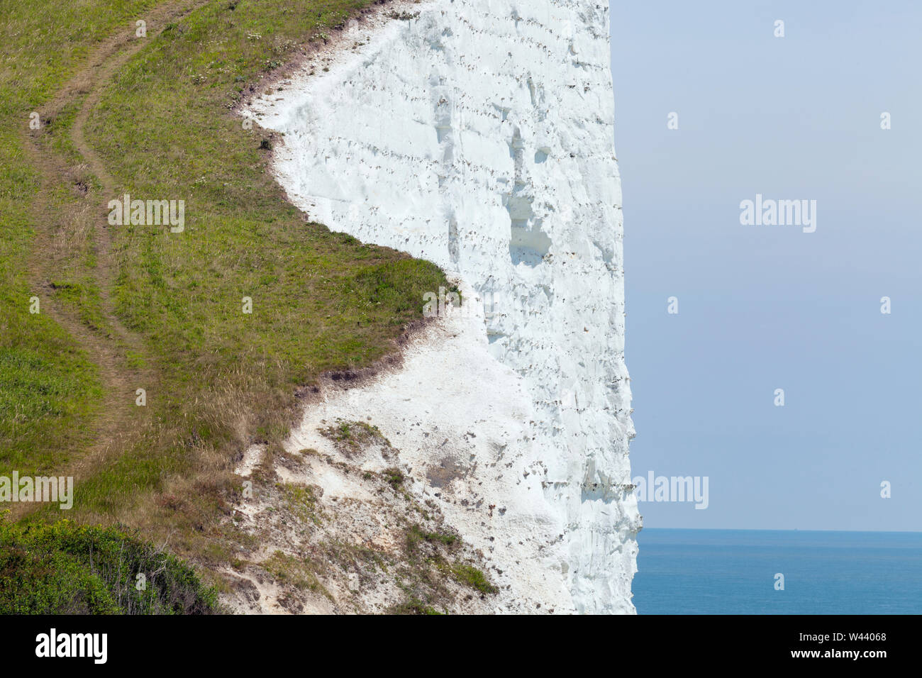 Steep coastal path going up on the edge of white cliff, Dover, Kent, England, on a sunny summer day . Stock Photo