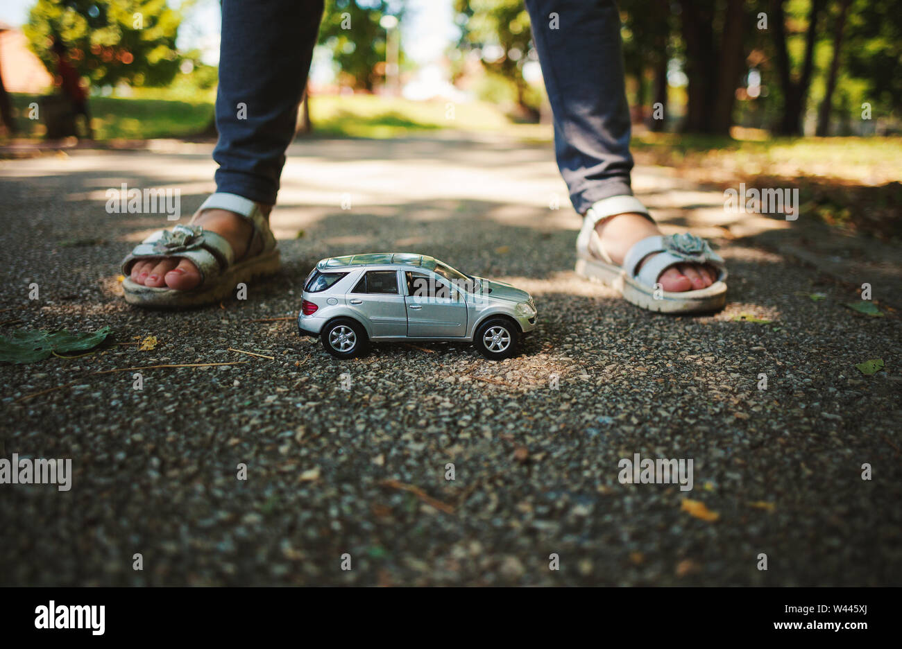Little girl in park playing with car toy Stock Photo - Alamy