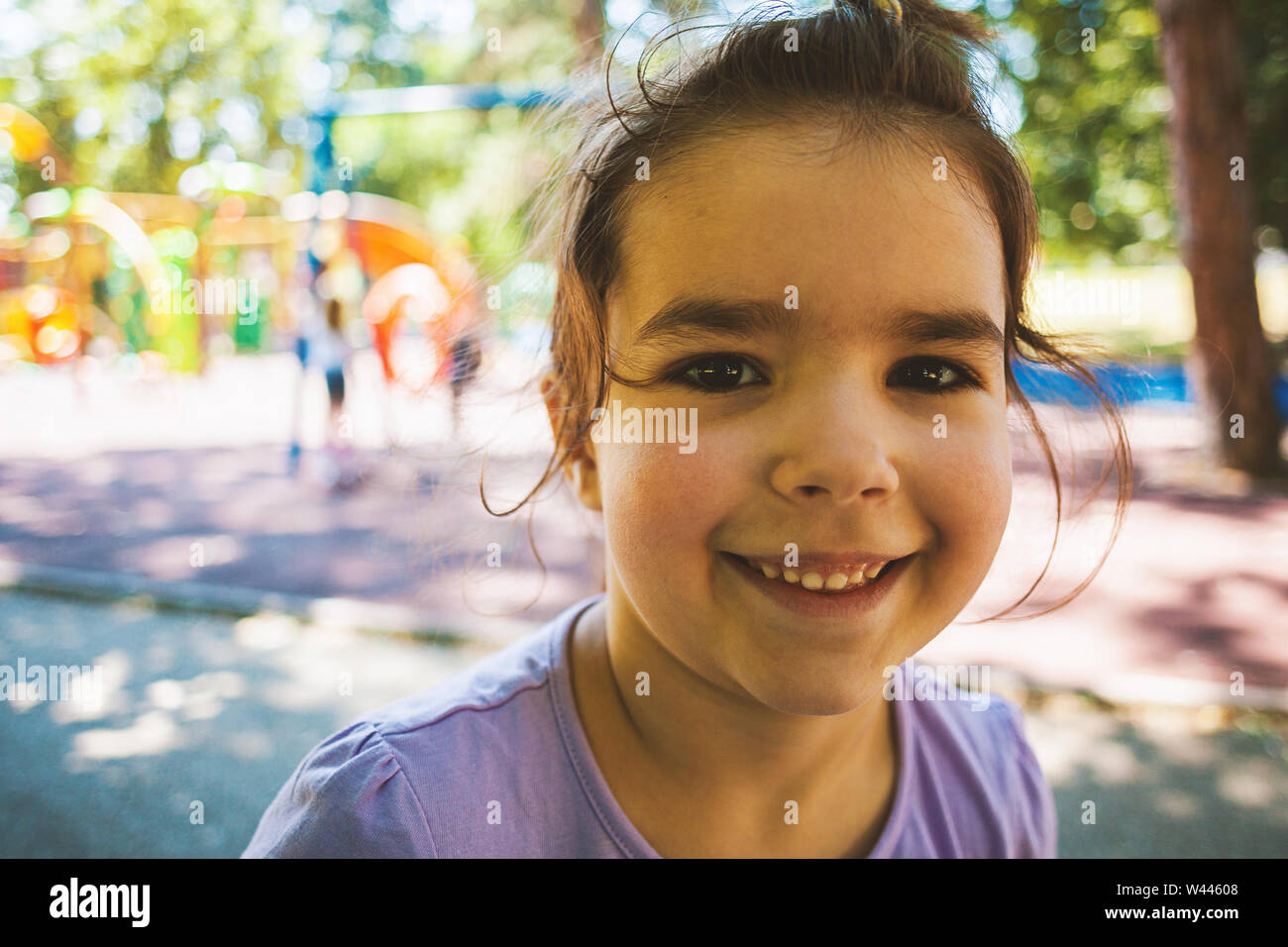 Portrait of a little girl smiling in park during summer day Stock Photo ...