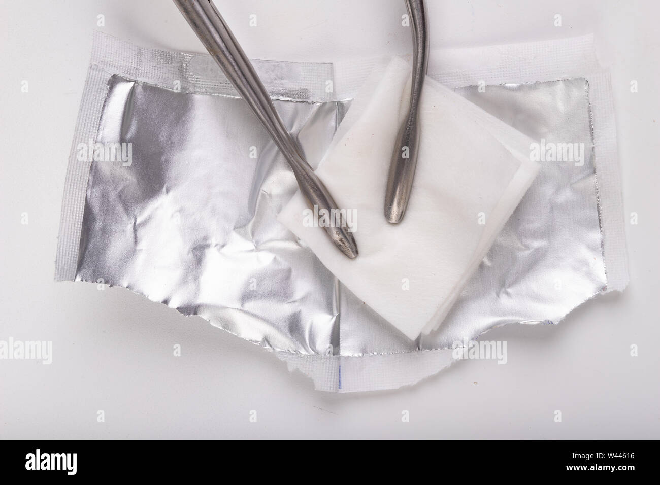 Cotton swab soaked in alcohol in metal medical pliers. Doctor's