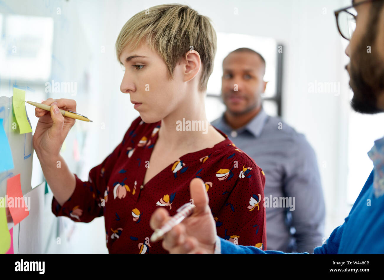 Platinum pixie cut female boss led multi-ethnic group hipster trendy business people during a brainstorm session for their small company Stock Photo