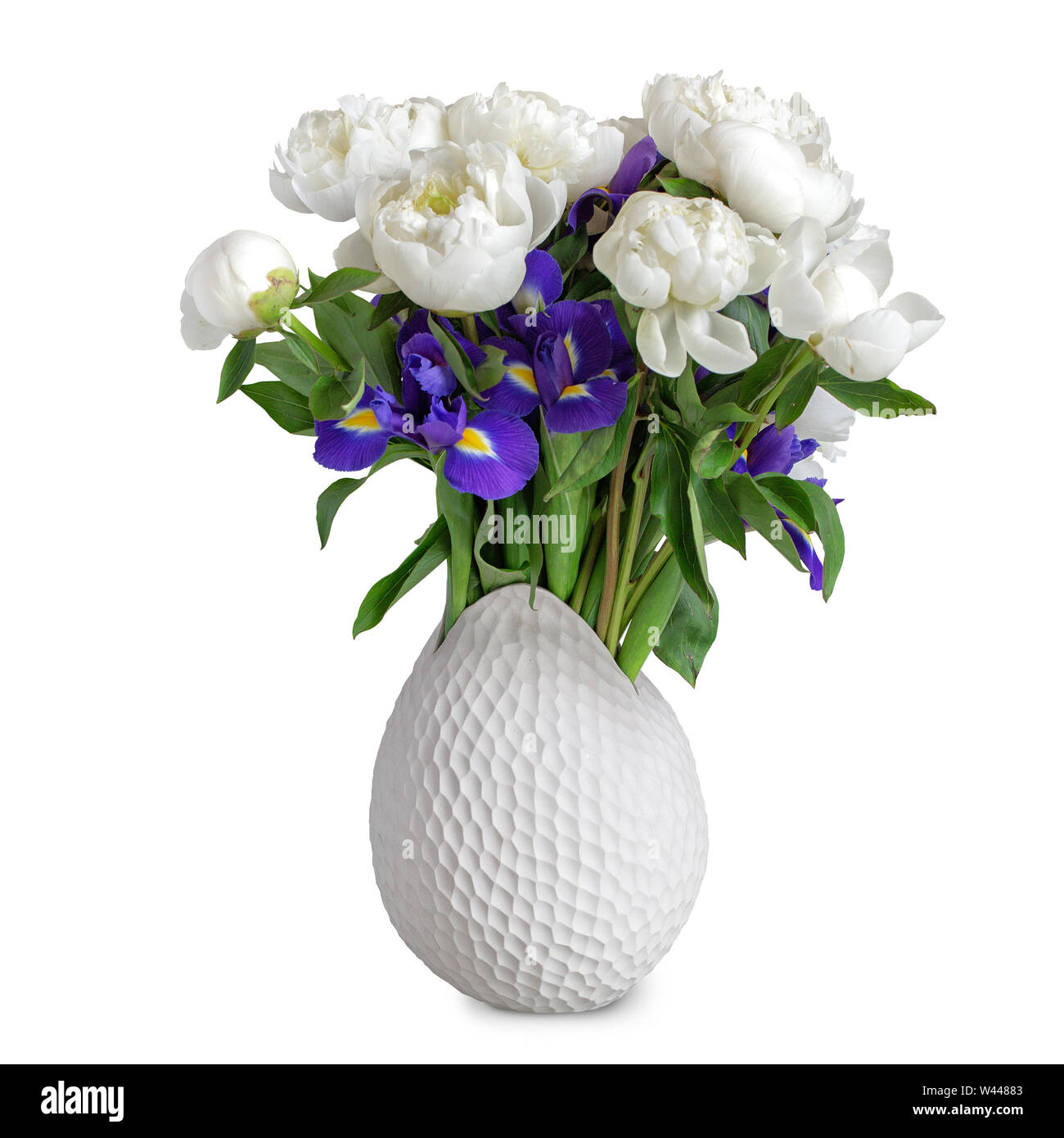 Bouquet of white peonies and irises in a white vase isolated on white