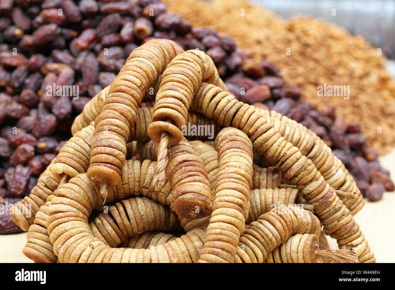 Big dried dates and dried figs strung on twine, lying on a large