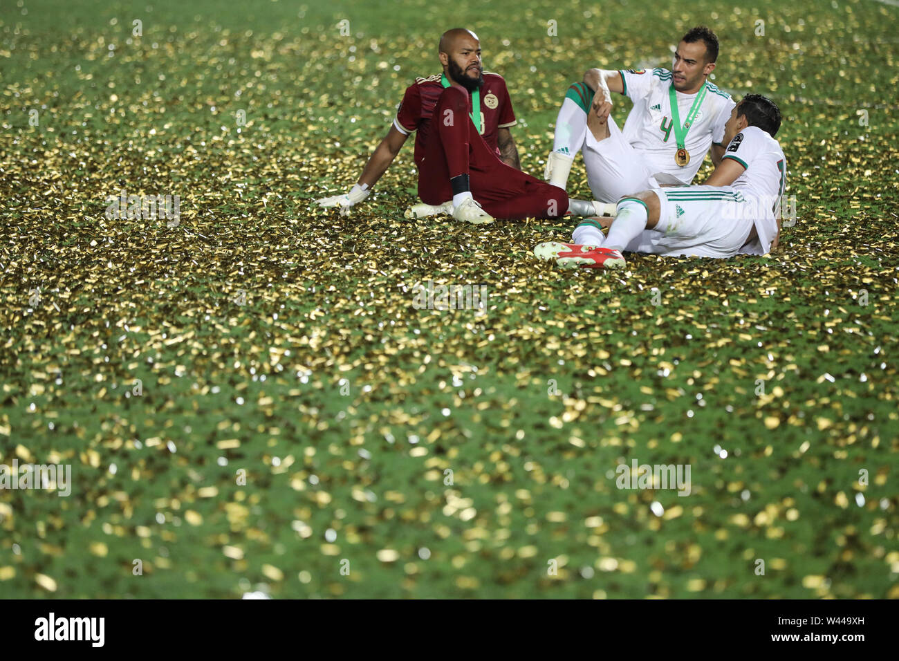 Cairo, Egypt. 19th July, 2019. Algeria's Rais M'Bolhi (L-R), Djamel Benlamri and Mehdi Zeffane celebrate with the trophy after Algeria defeated Senegal in the 2019 Africa Cup of Nations final soccer match at the Cairo International Stadium. Credit: Oliver Weiken/dpa/Alamy Live News Stock Photo