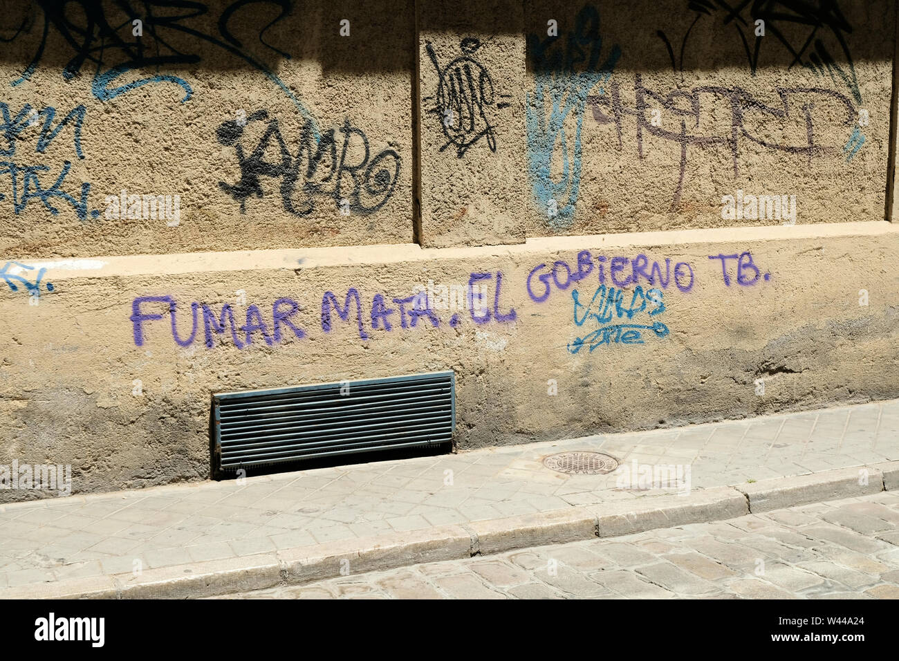 Smoking kills and so does the government; anti-government political graffiti in Granada, Spain; against anti-smoker campaigns and those in politics. Stock Photo