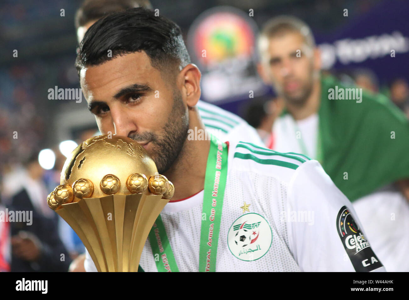 Cairo, Egypt. 19th July, 2019. Algeria's Riyad Mahrez kisses the trophy during celebrations after Algeria defeated Senegal in the 2019 Africa Cup of Nations final soccer match at the Cairo International Stadium. Credit: Omar Zoheiry/dpa/Alamy Live News Stock Photo