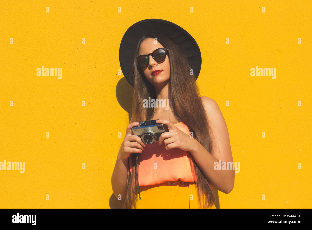 Young girl standing outdoor in front a colorful wall Stock Photo - Alamy