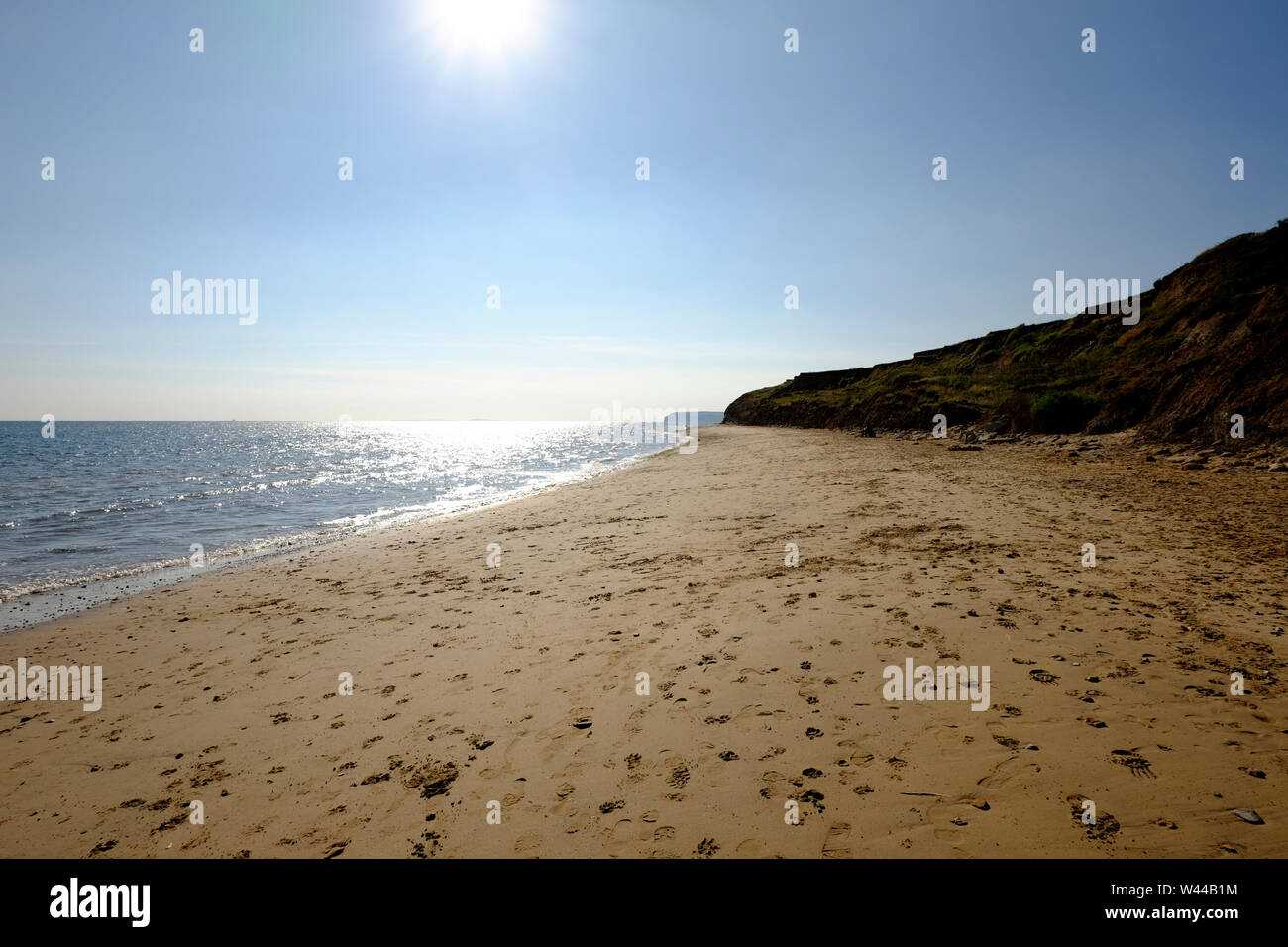 View at low tide on a calm sunny day along the sandy beach at Chilton Chine, Compton Bay, Isle of Wight Stock Photo