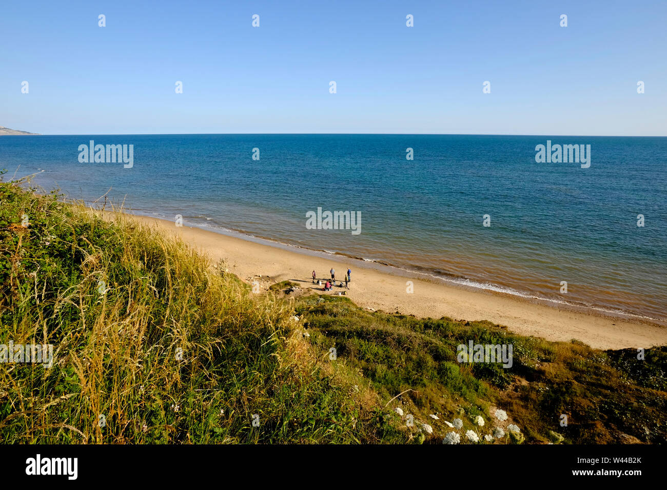 A group of men fishing friends on the beach meeting up to fish at Chilton Chine, Compton Bay, Isle of Wight Stock Photo