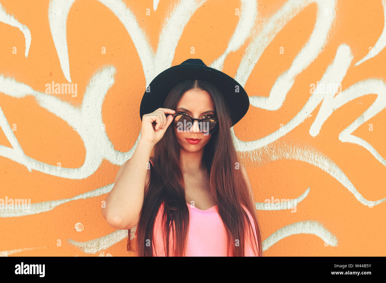 Young girl standing outdoor in front a colorful wall Stock Photo - Alamy
