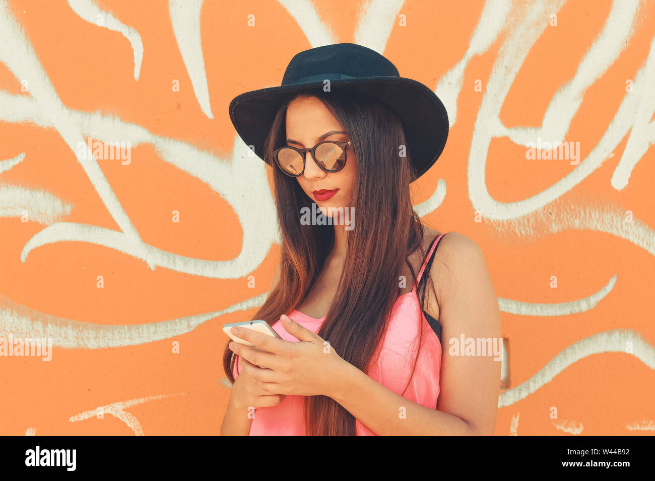 Young girl standing outdoor in front a colorful wall Stock Photo - Alamy