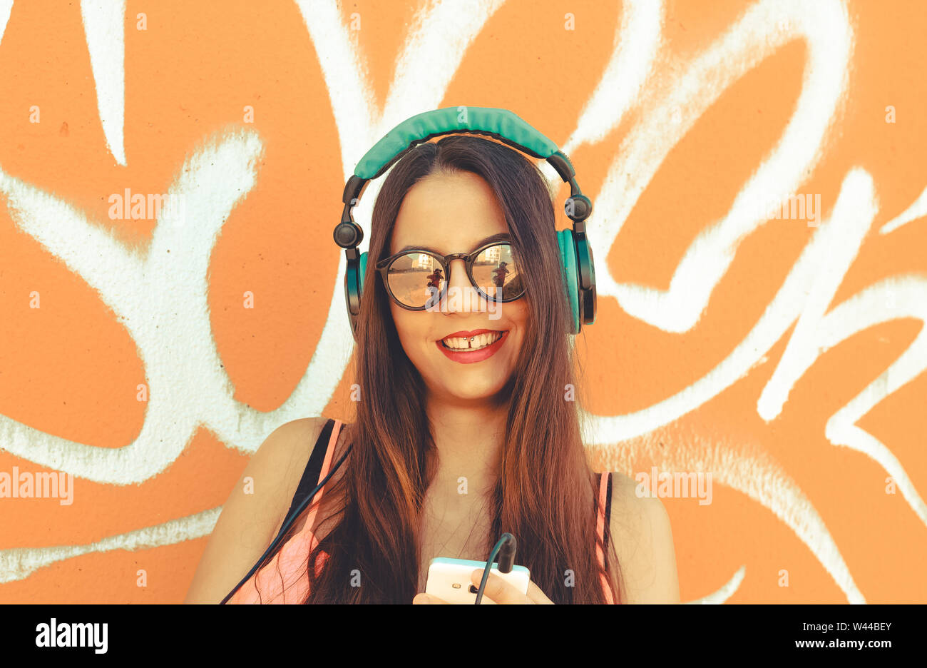 Young girl standing outdoor in front a colorful wall Stock Photo - Alamy