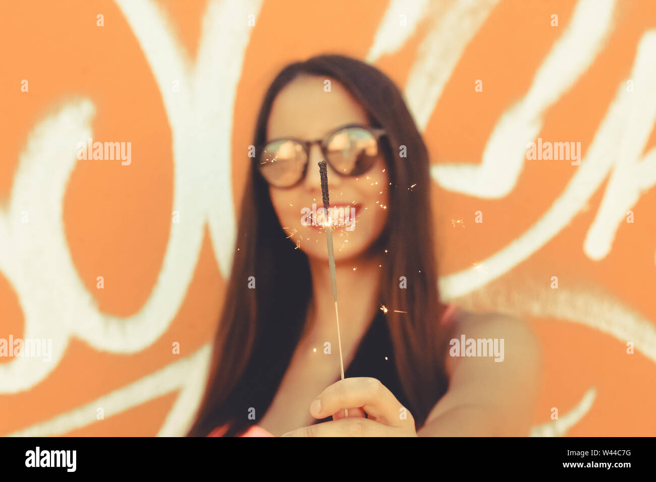Young girl standing outdoor in front a colorful wall Stock Photo - Alamy