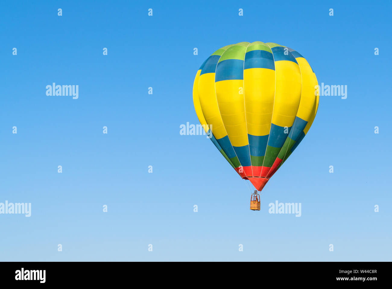 One colorful hot air balloon in blue sky Stock Photo - Alamy