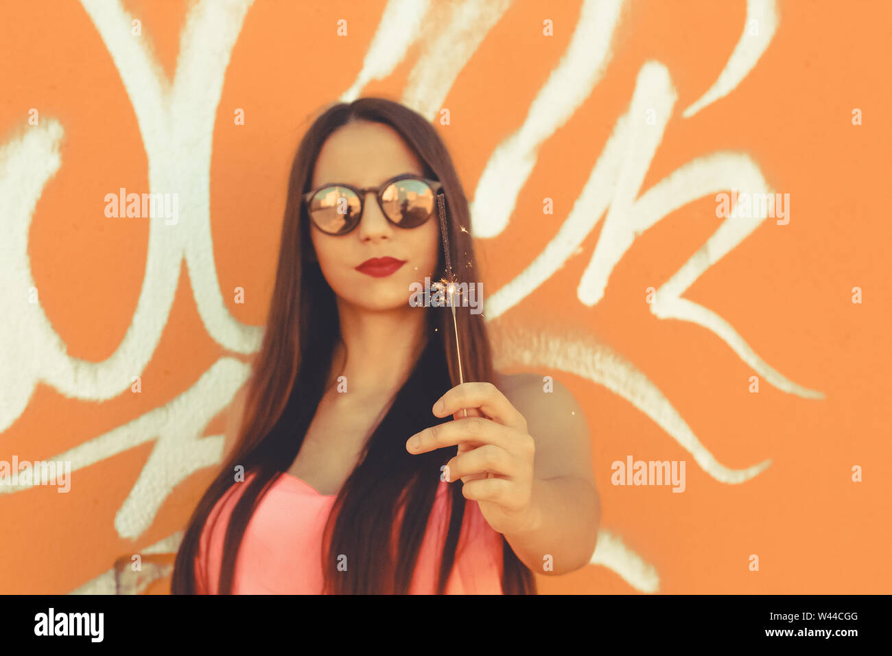 Young girl standing outdoor in front a colorful wall Stock Photo - Alamy