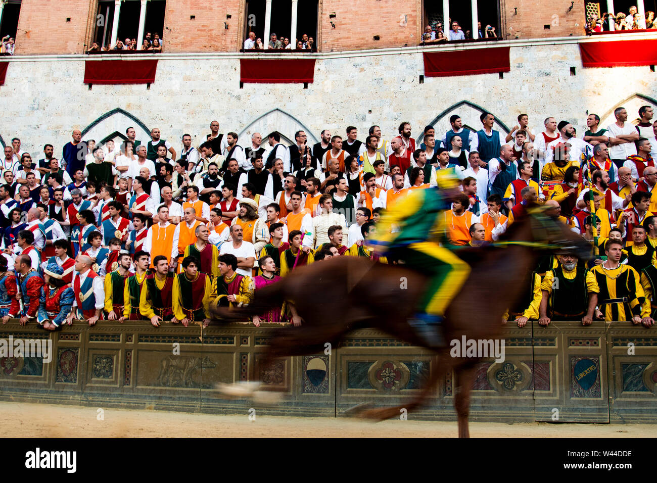 Horse races past people in the audience at the Palio in Siena, Italy Stock Photo