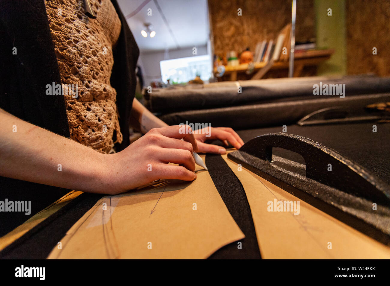 A close-up view on the hands of a female tailor working inside her ...
