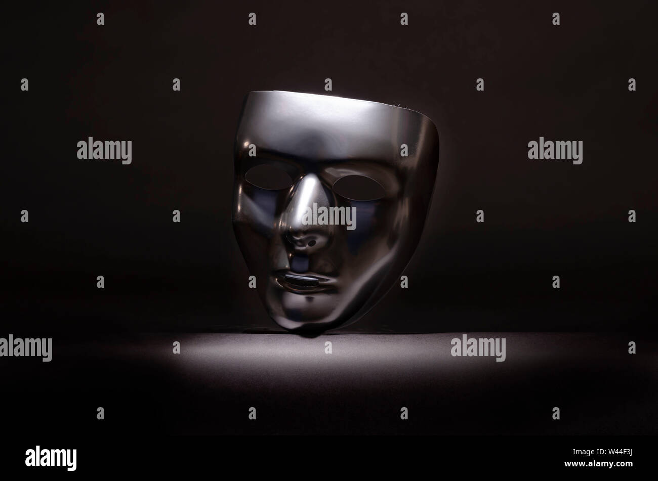 Silver masquerade mask on a black background Stock Photo - Alamy