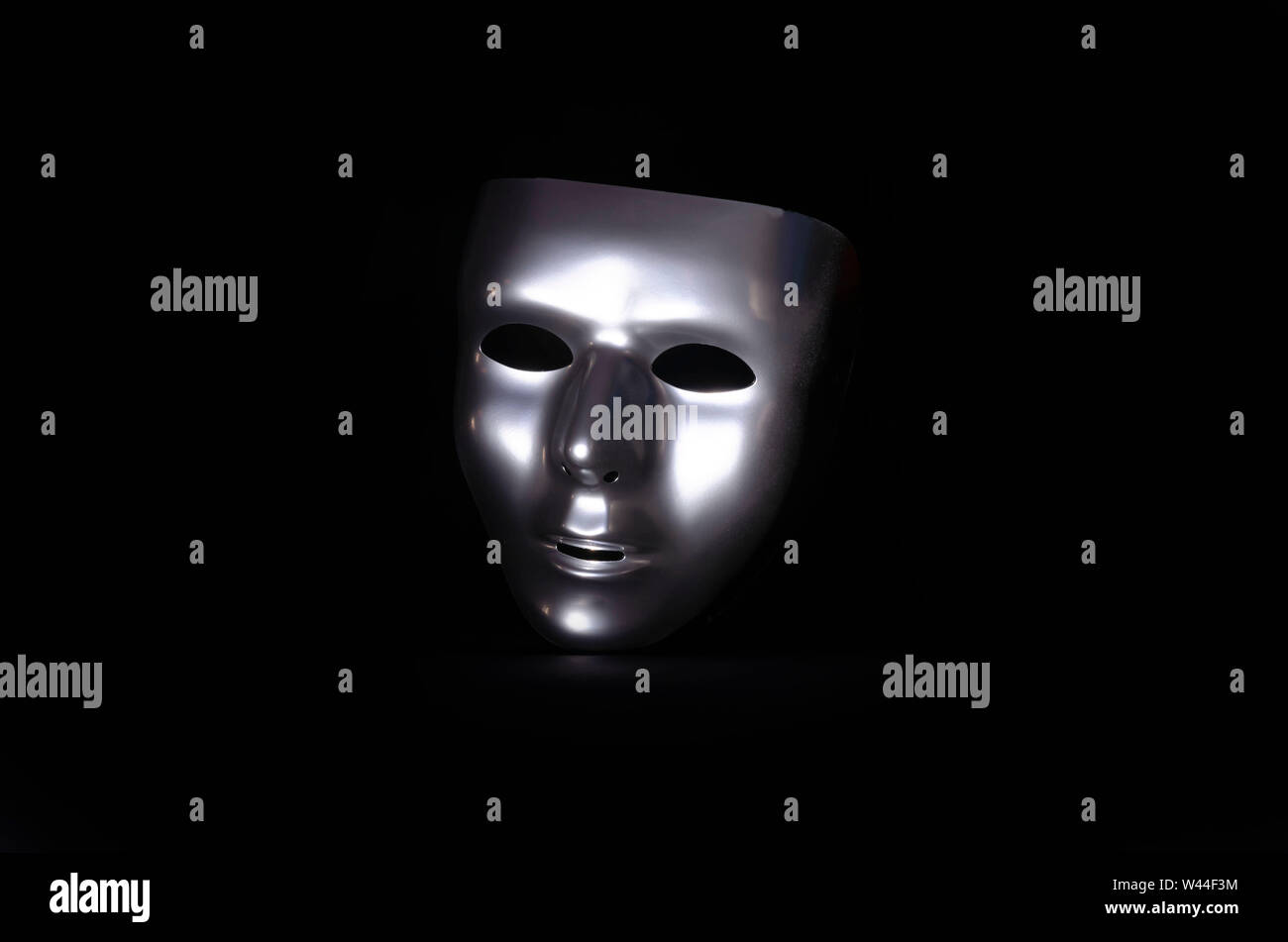 Silver masquerade mask on a black background Stock Photo - Alamy