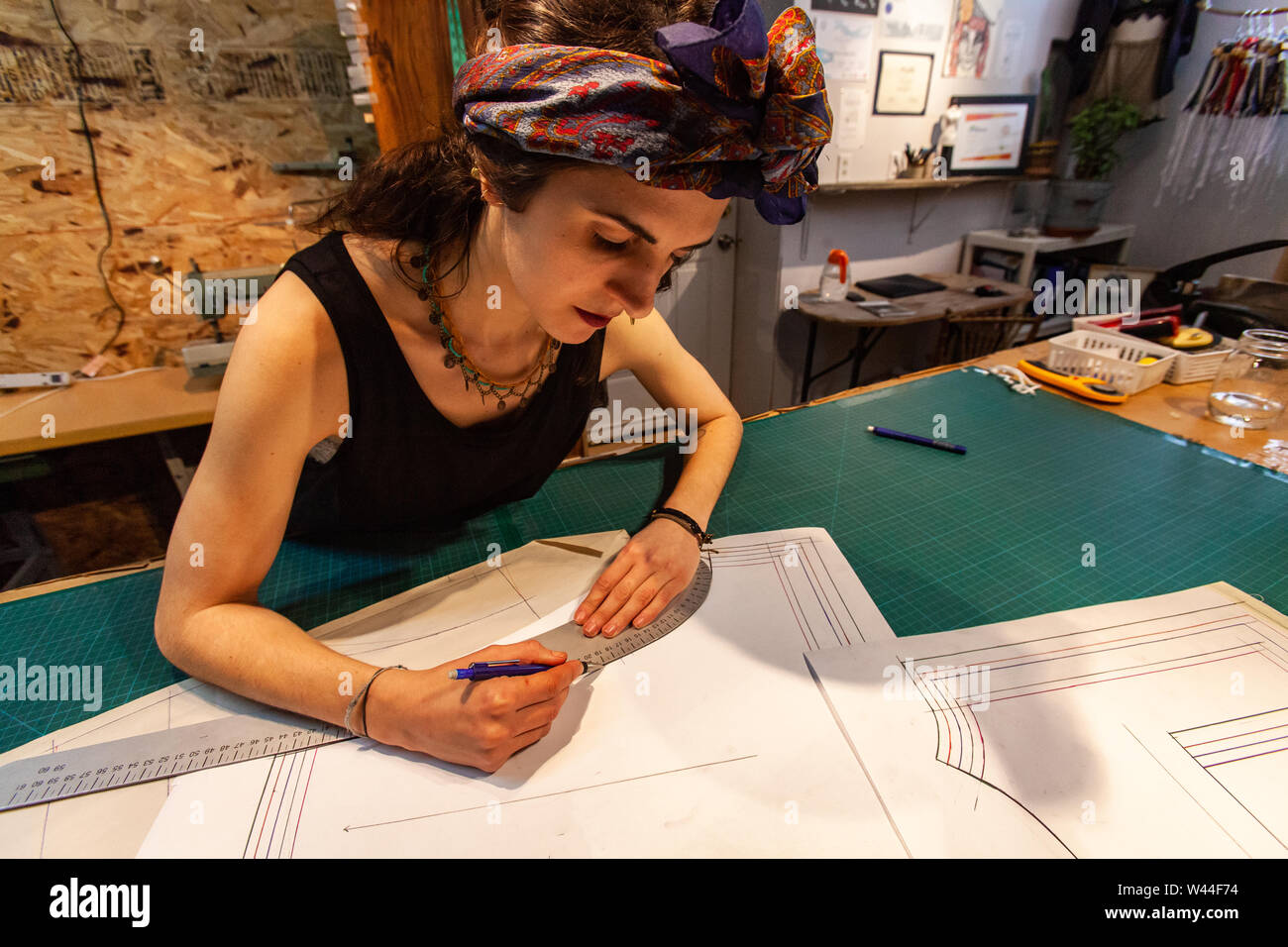 A close-up view of an eco-friendly female tailor sketching new design ...